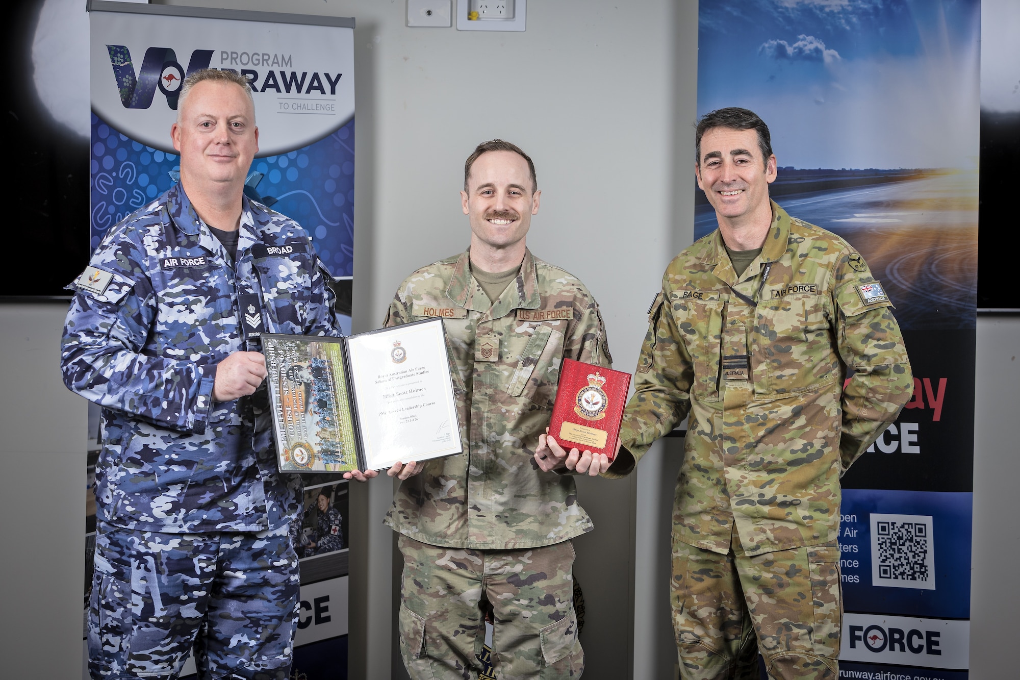 Airmen pose for a photo with awards.