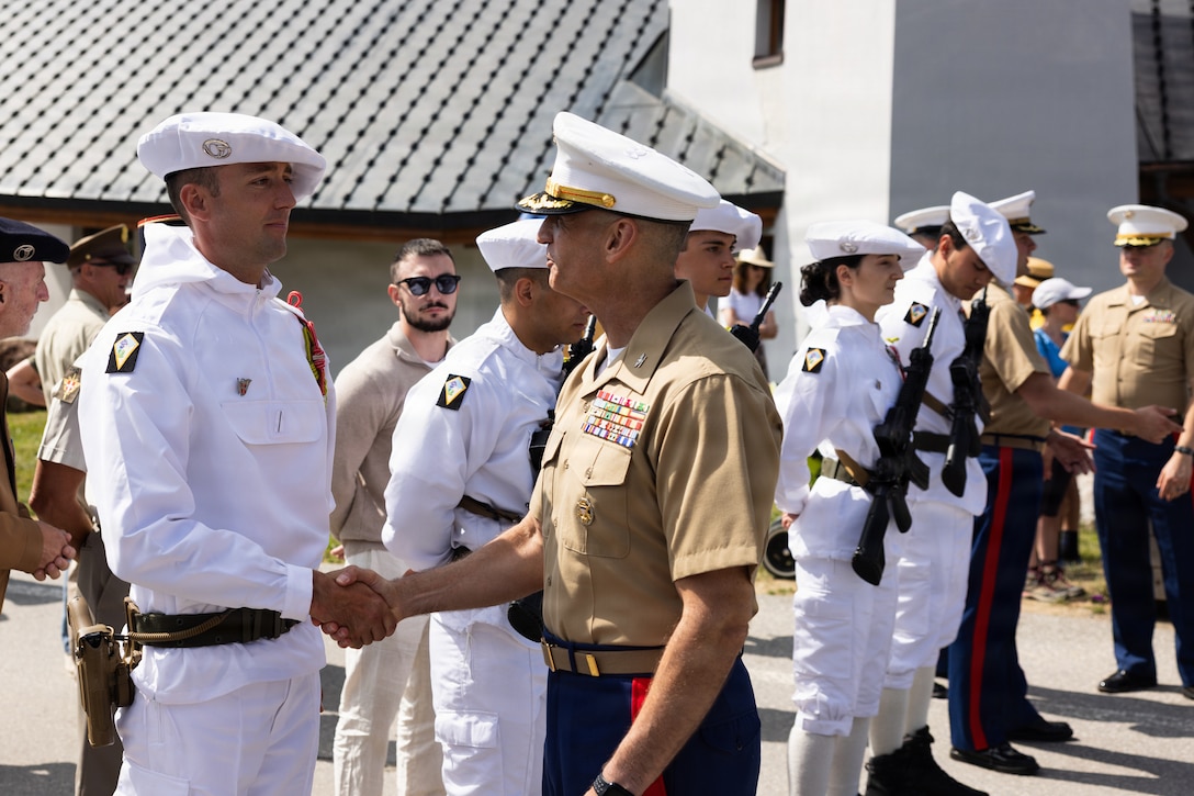 U.S. Marine Corps Col. Joel DeLuca, deputy commander, U.S. Marine Corps Forces Europe and Africa, greets French soldiers with the 13th Battaillon de Chasseurs Alpins in Les Saisies, France, Aug. 1, 2026. The ceremony commemorated the 82nd anniversary of Operation Union II, a WWII operation that involved the aerial insertion of six Marines, an Army Air Corps captain, and a French resistance fighter into the German-controlled French Alps in August of 1944. Their mission was to arm and train the French Resistance to aid in the fight to liberate Europe. When they found themselves surrounded by German forces in the village of Centron, the Marines surrendered in order to save the village from retaliation. Their sacrifice is remembered to this day. (U.S. Marine Corps photo by Sgt. Kedrick Schumacher)
