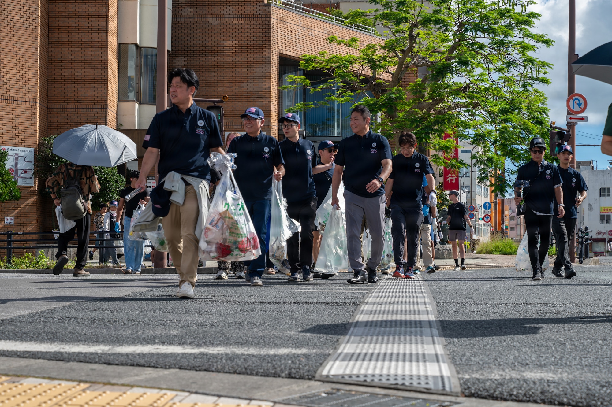 Service members and locals pick up trash.
