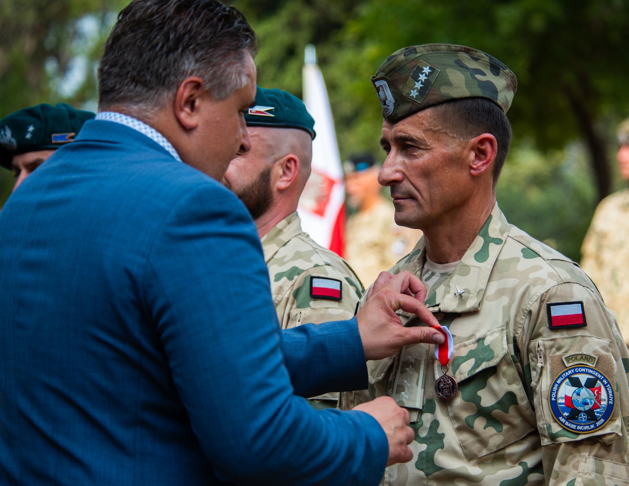 Andrzej Dudzinski, Polish Deputy Ambassador to Türkiye, places a medal on a member assigned to the Polish Military Contingent