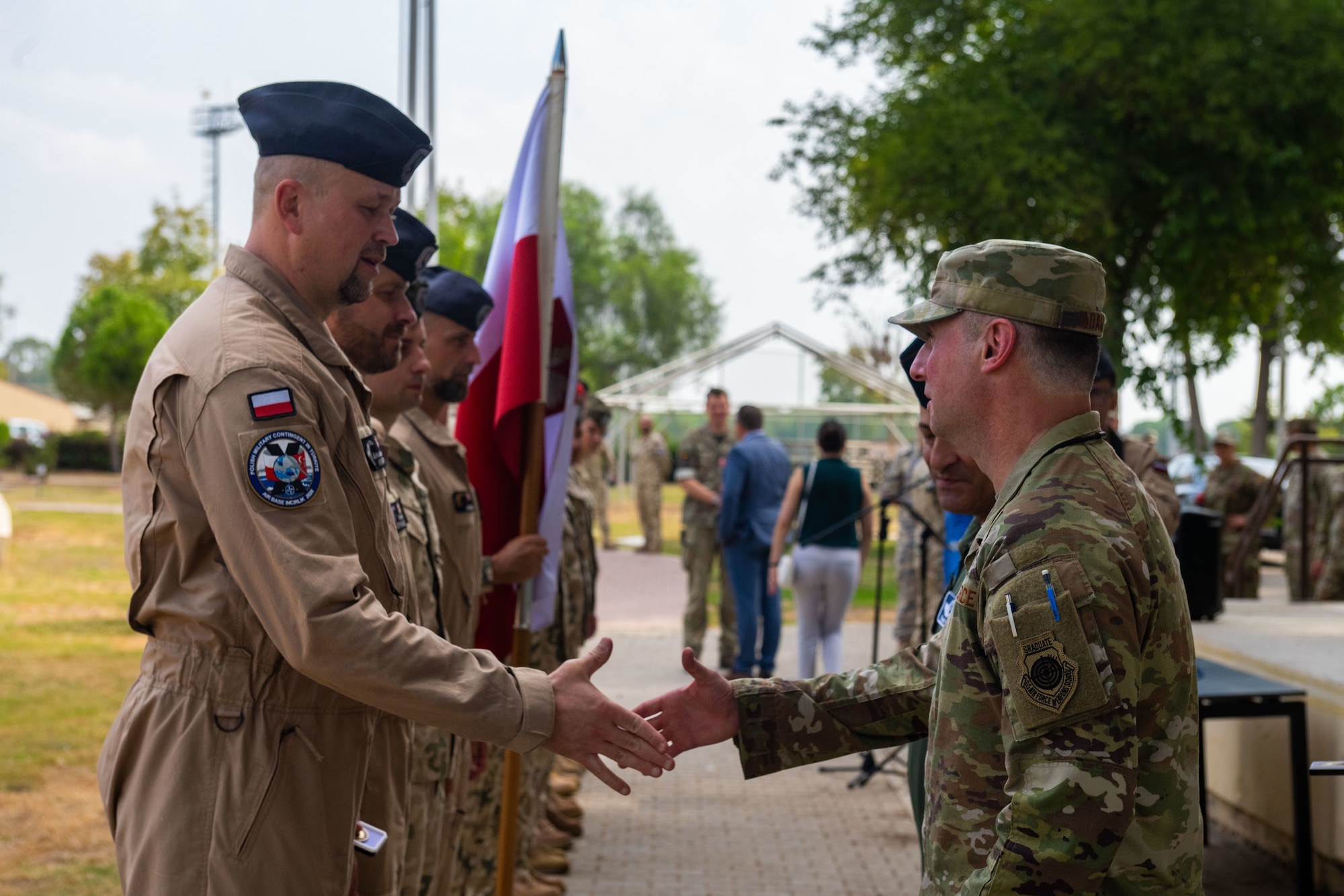 Polish Lt. Col. Arkadiusz Wirkus, Polish Military Contingent commander, shakes hands with U.S. Air Force Col. Isaac Adams, 39th Air Base Wing commander,
