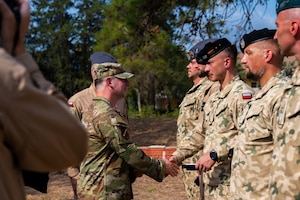 U.S. Air Force Col. Isaac Adams, 39th Air Base Wing commander, congratulates a member assigned to the Polish Military Contingent