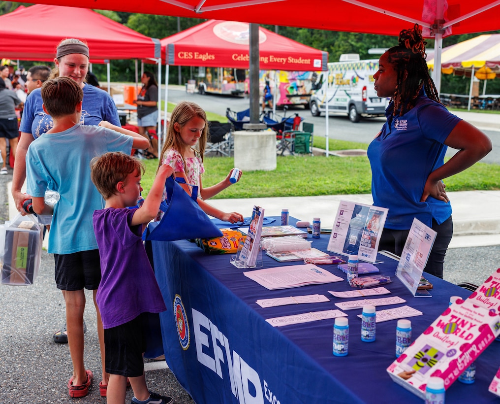 Community members interact with a vendor’s booth during National Night Out at the Crossroads Elementary School on Marine Corps Base Quantico, Virginia, Aug. 4, 2026. National Night Out is an annual community-building campaign that enhances the relationships between law enforcement, first and emergency responders with members of the local community. (U.S. Marine Corps photo by Lance Cpl. Donavan E. Melendez)