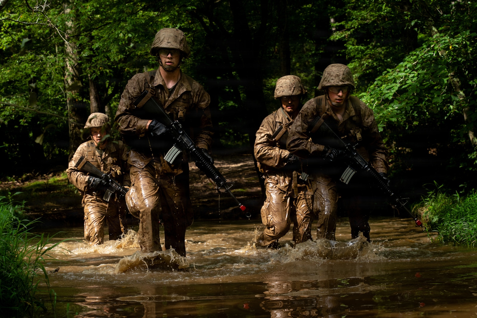 U.S. Marine Corps officer candidates with Officer Candidate School patrol through a body of water on the Combat Course at OCS on Marine Corps Base Quantico, Virginia, Aug. 3, 2026. The Combat Course tests officer candidates’ endurance and ability to navigate obstacles under pressure in a simulated combat environment. (U.S. Marine Corps photo by Cpl. Joshua Munsen)