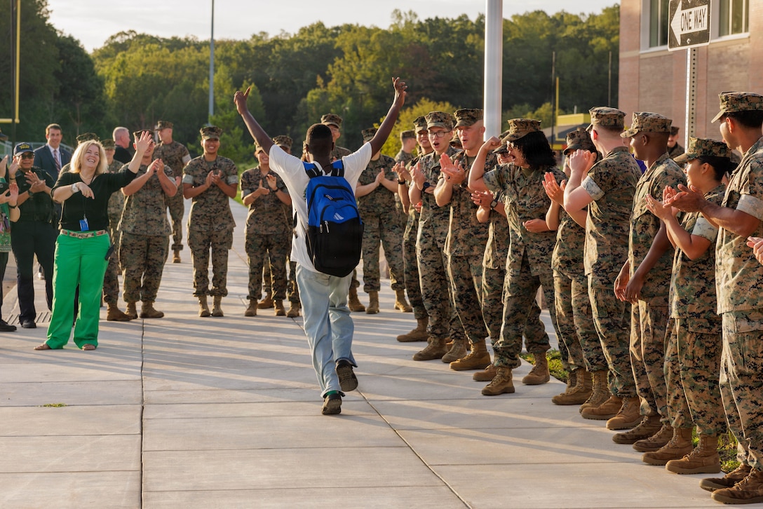 U.S. Marines with Marine Corps Base Quantico welcome a student to their first day of school during a back-to-school celebration at the Quantico Middle-High School on Marine Corps Base Quantico, Virginia, Aug. 17, 2026. This event welcomed students back to the classrooms, strengthening the bonds between the Marines and the MCB Quantico community. (U.S. Marine Corps photo by Lance Cpl. Federico Marquez)