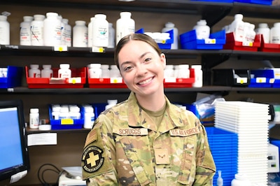 Service member smiles in front of pharmacy shelves