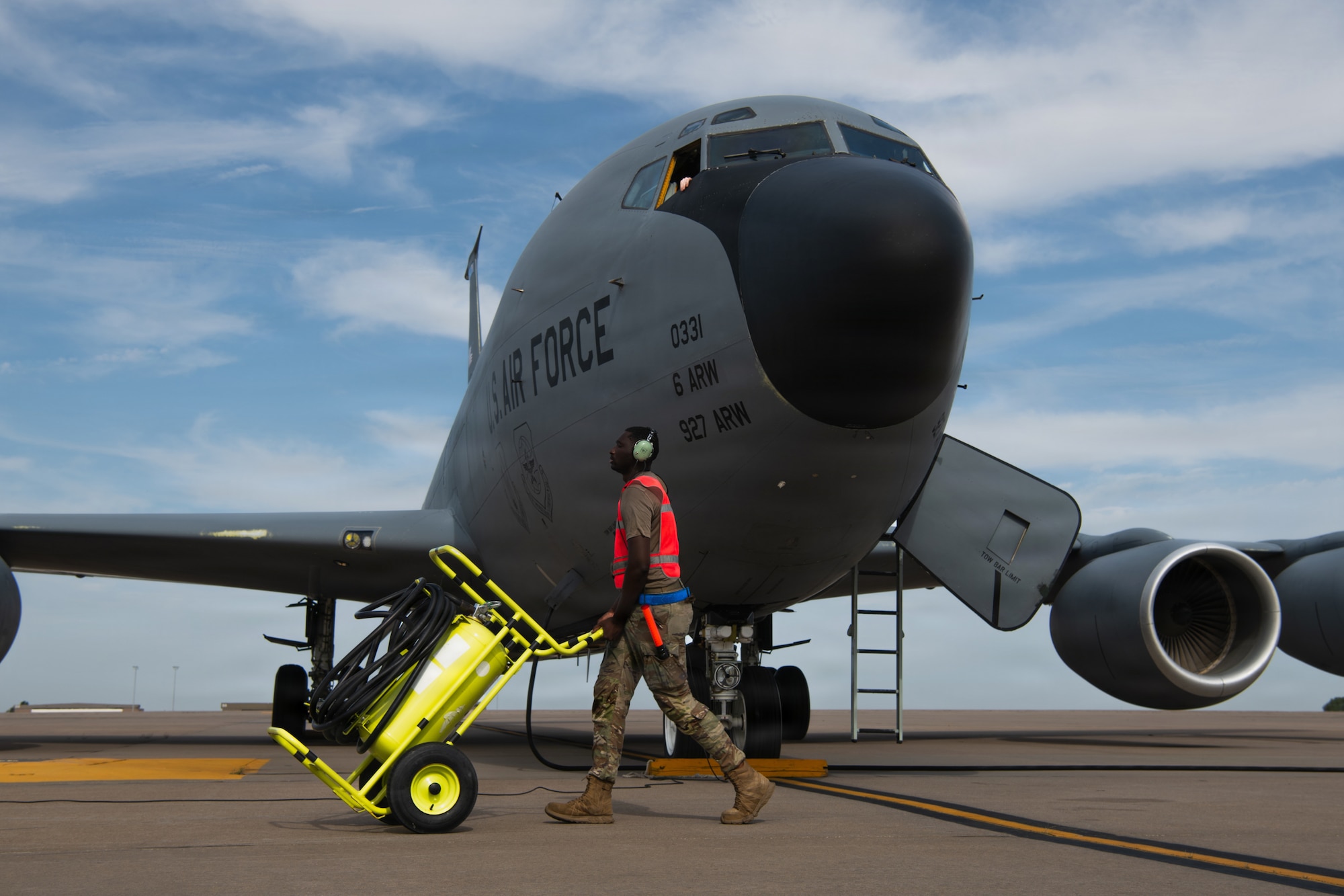 U.S. Air Force Senior Airman Tyrone Banks, 722nd Aircraft Maintenance Squadron crew chief, moves a fire bottle at McConnell Air Force Base, Kansas, Aug. 14, 2026. Fire bottles are moved from engine to engine during the startup sequence to ensure each engine has immediate access to fire protection as it is started. The bottles hold a pressurized fire-extinguishing agent that can be released into the engine area to suppress an engine fire quickly. (U.S. Air Force photo by Airman Matthew Nguyen)