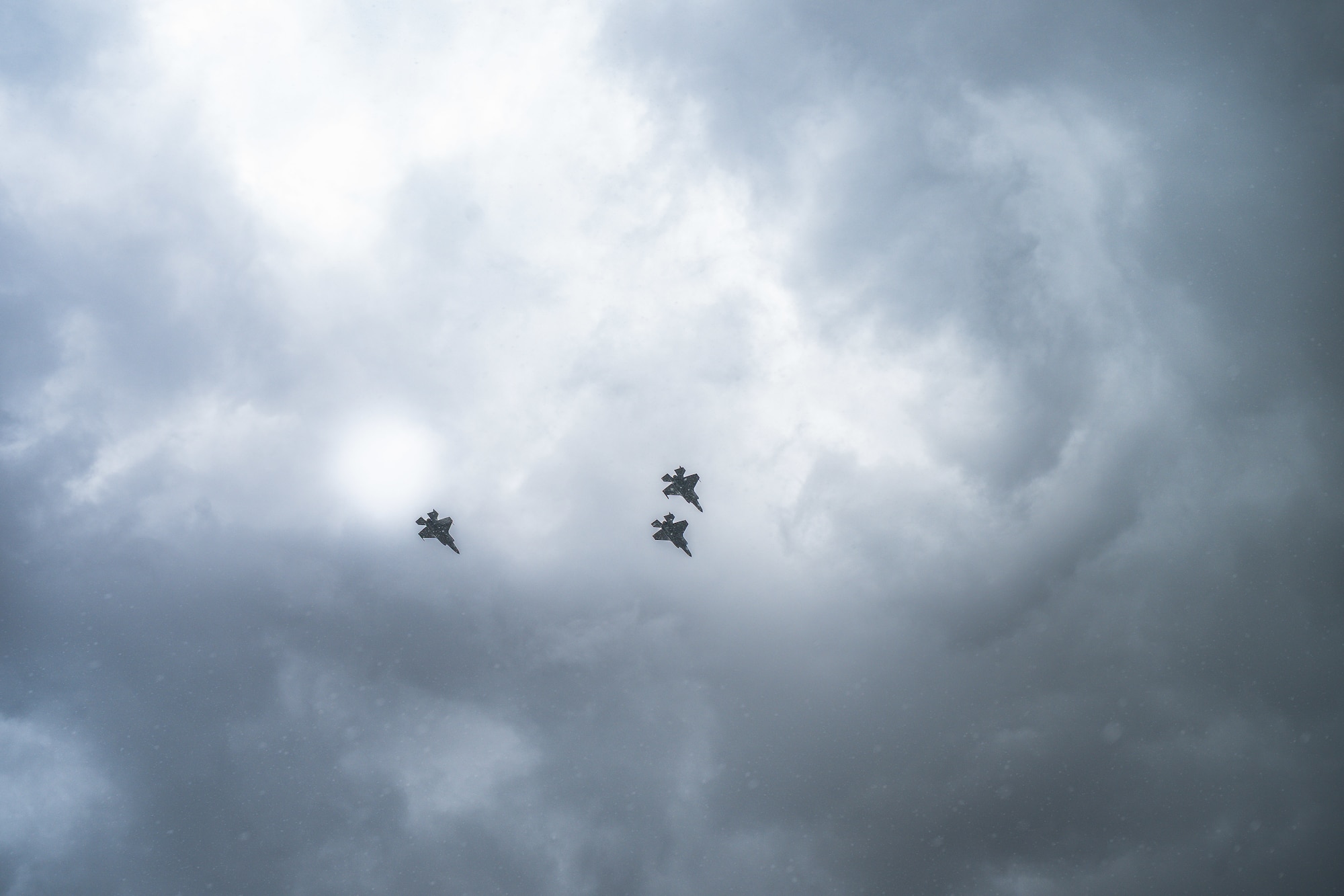 A photo of three Air Force F-35A Lightning IIs rendering honors at a funeral by performing a missing man formation.