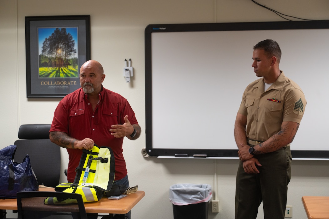 Mark Dumdie, 17th Training Wing Safety motorcycle safety program manager, explains how an airbag vest functions during a motorcycle safety meeting at Goodfellow Air Force Base, Texas, Aug. 14, 2026. The vest includes a lanyard that attaches to a motorcycle seat or horse saddle, and it features a gas cartridge that will automatically inflate the airbag once it detects a fall or accident that ejects the rider. (U.S. Air Force Photo by Senior Airman Brian Lummus)
