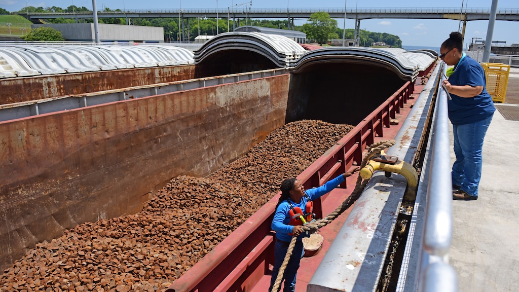Lock Operator Mamie Cherry, U.S. Army Corps of Engineers Nashville District, assists Deck Hand Chase Nichols, Tennessee Valley Towing, with tying off a barge to the tow haulage unit July 20, 2026, at Wilson Lock on the Tennessee River in Florence, Alabama. USACE operates and maintains the lock at the Tennessee Valley Authority project. (USACE Photo by Lee Roberts)
