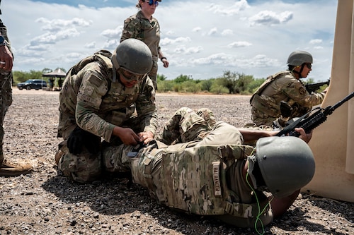 U.S. Airmen participating in an Advanced Ready Training Core course move with weapons to rescue a simulated casualty at Davis-Monthan Air Force Base, Arizona, Aug. 6, 2026. The scenario combined tactical movement and casualty evacuation procedures to strengthen expeditionary readiness and develop mission-essential warfighting skills. (U.S. Air Force photo by Airman 1st Class Samantha Melecio)