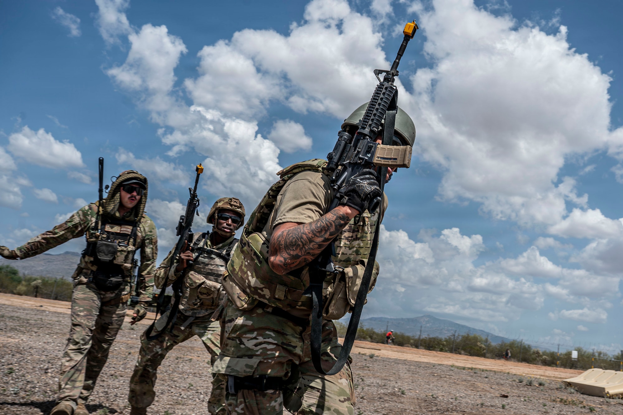 U.S. Airmen participating in an Advanced Ready Training Core course move with weapons to rescue a simulated casualty at Davis-Monthan Air Force Base, Arizona, Aug. 6, 2026. The scenario combined tactical movement and casualty evacuation procedures to strengthen expeditionary readiness and develop mission-essential warfighting skills. (U.S. Air Force photo by Airman 1st Class Samantha Melecio)