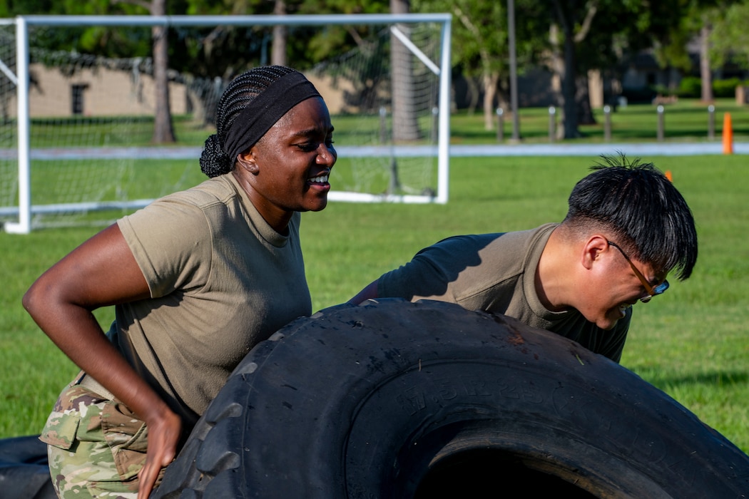 Airmen flip a tire during exercise