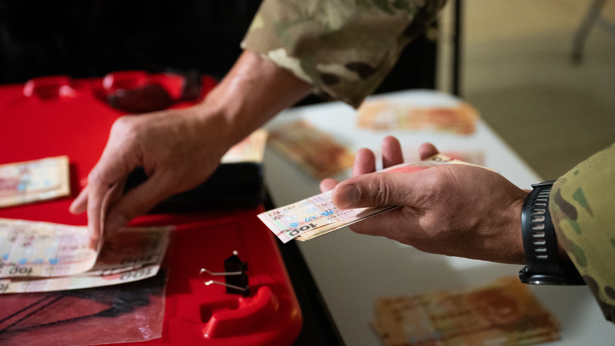 An Airman counts foreign currency by hand.