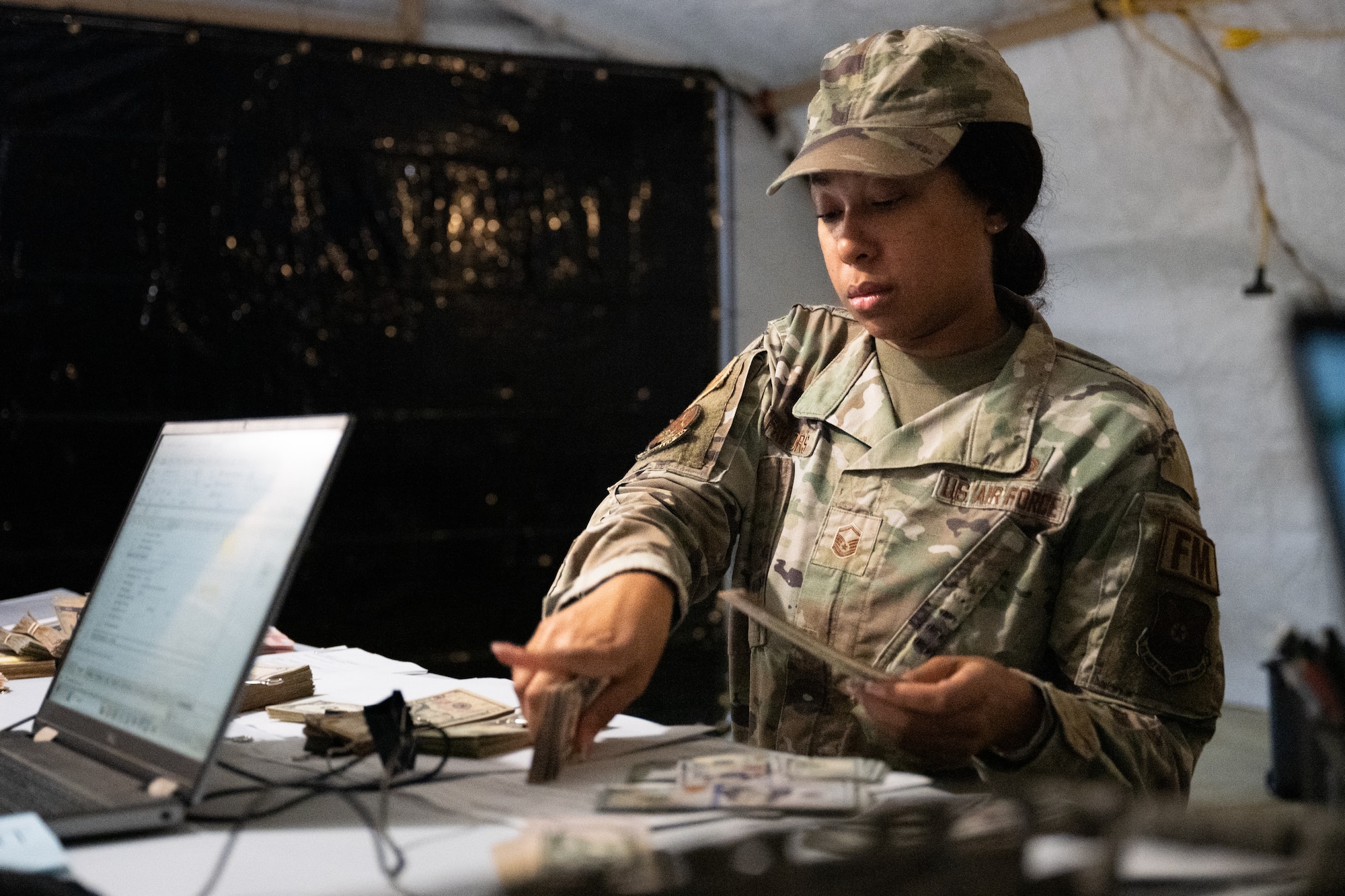 An Airman counts physical cash.
