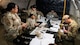 5th Comptroller Squadron Airmen review financial paperwork inside a deployment tent during an exercise.