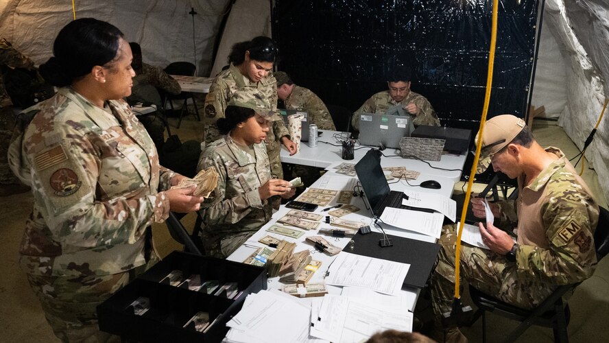 5th Comptroller Squadron Airmen review financial paperwork inside a deployment tent during an exercise.