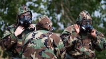 Airmen put on Mission Oriented Protective Posture gear.