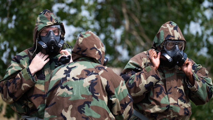 Airmen put on Mission Oriented Protective Posture gear.