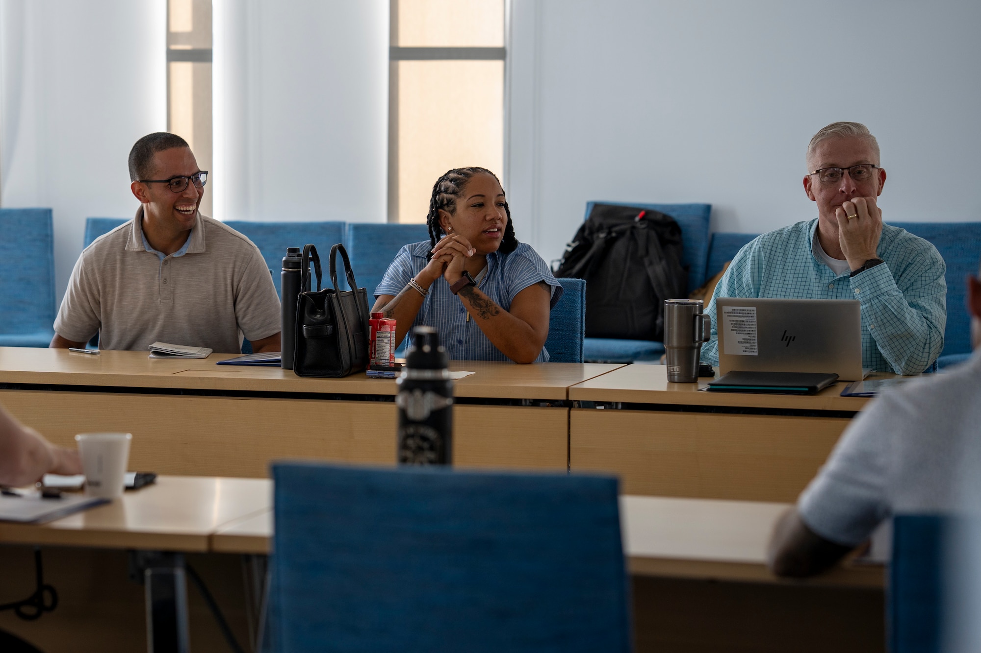 Two men and a woman sit at a table.