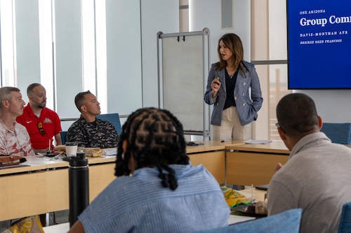 A woman presents a powerpoint to a group of people.