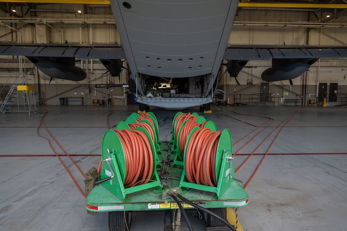 An Airman-designed aircraft engine compressor wash cart is connected to an AC-130J Ghostrider