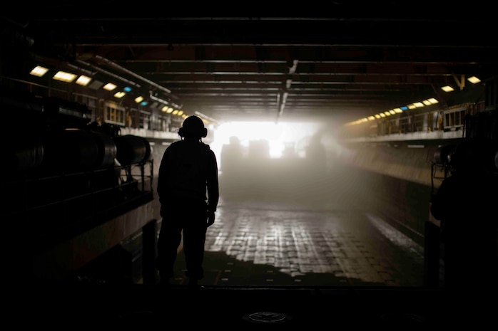 U.S. Sailors assigned to amphibious assault ship USS Essex (LHD 2) observe landing craft, air cushion with Assault Craft Unit 5, enter the ship’s well deck, Aug. 13.