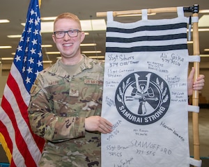 A man poses with a flag.
