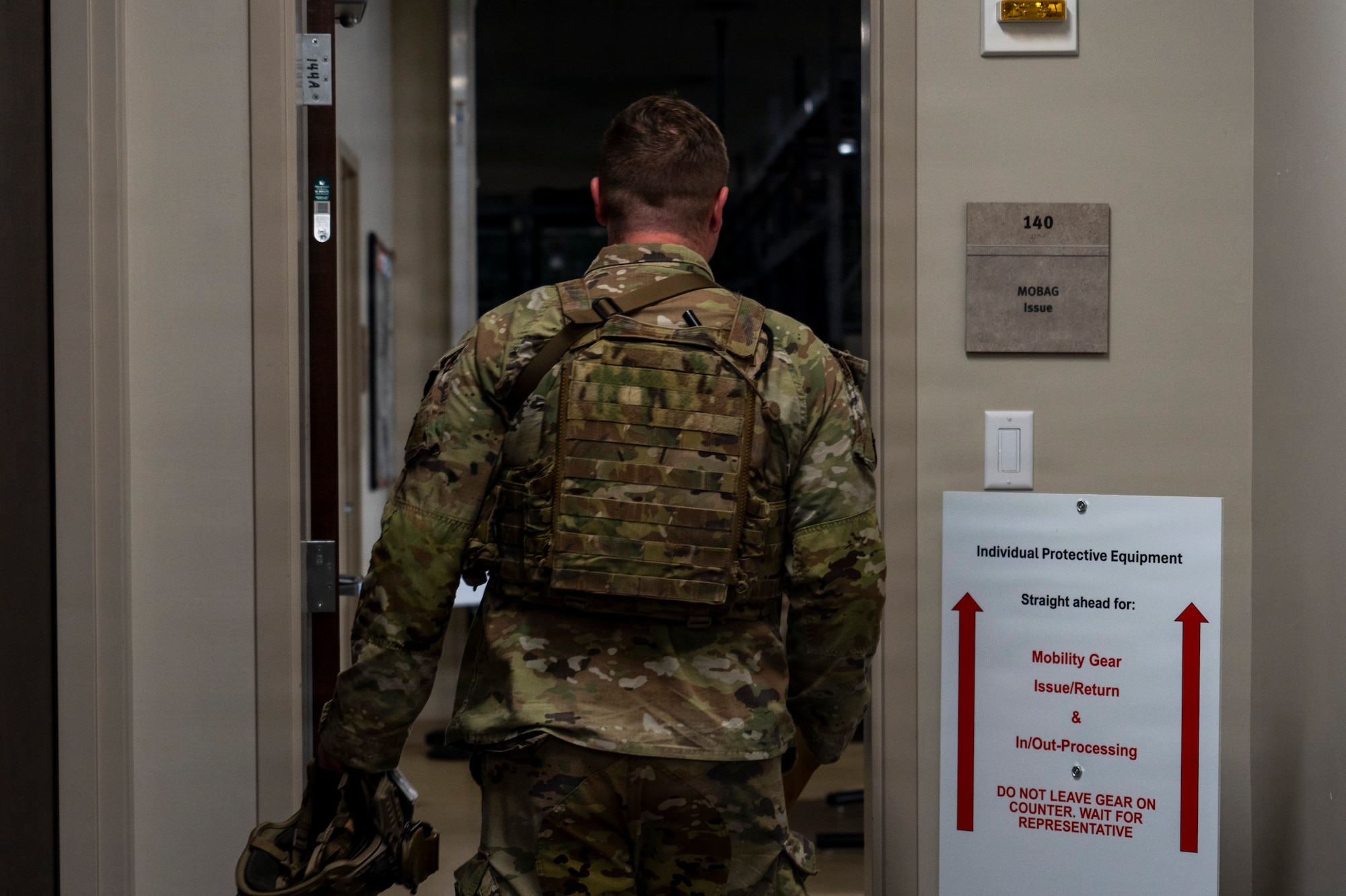 An Airman enters a door frame.