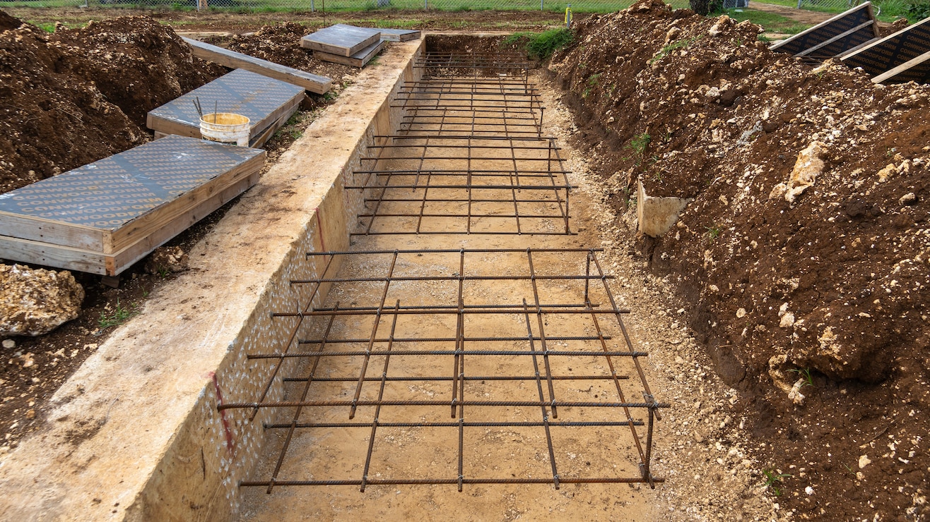 Steel rebar is connected to a concrete building foundation.
