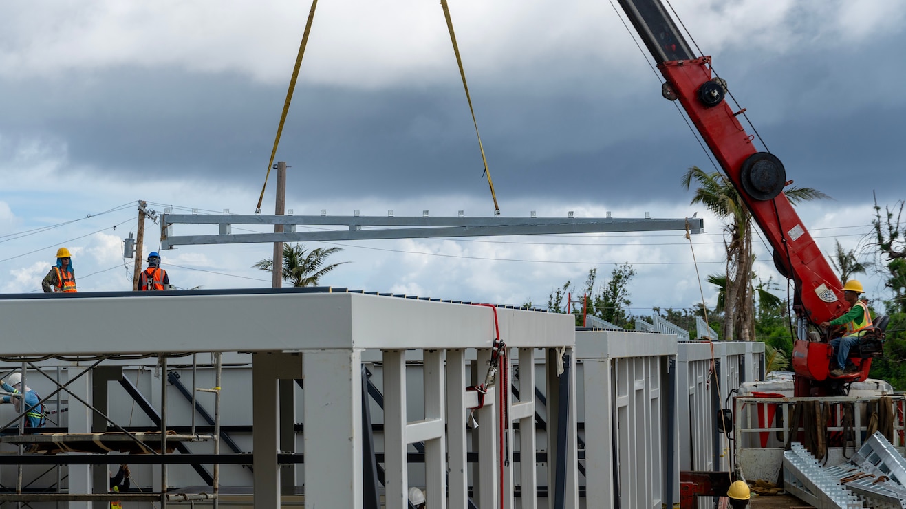 Construction workers assemble a steel building structure.