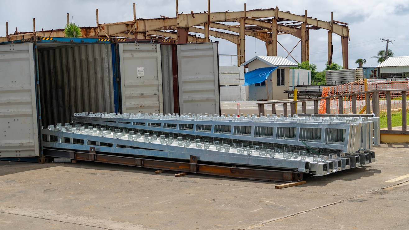 Construction workers assemble a steel building structure.