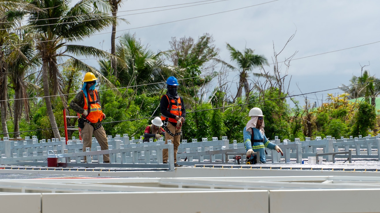 Construction workers assemble a steel building structure.