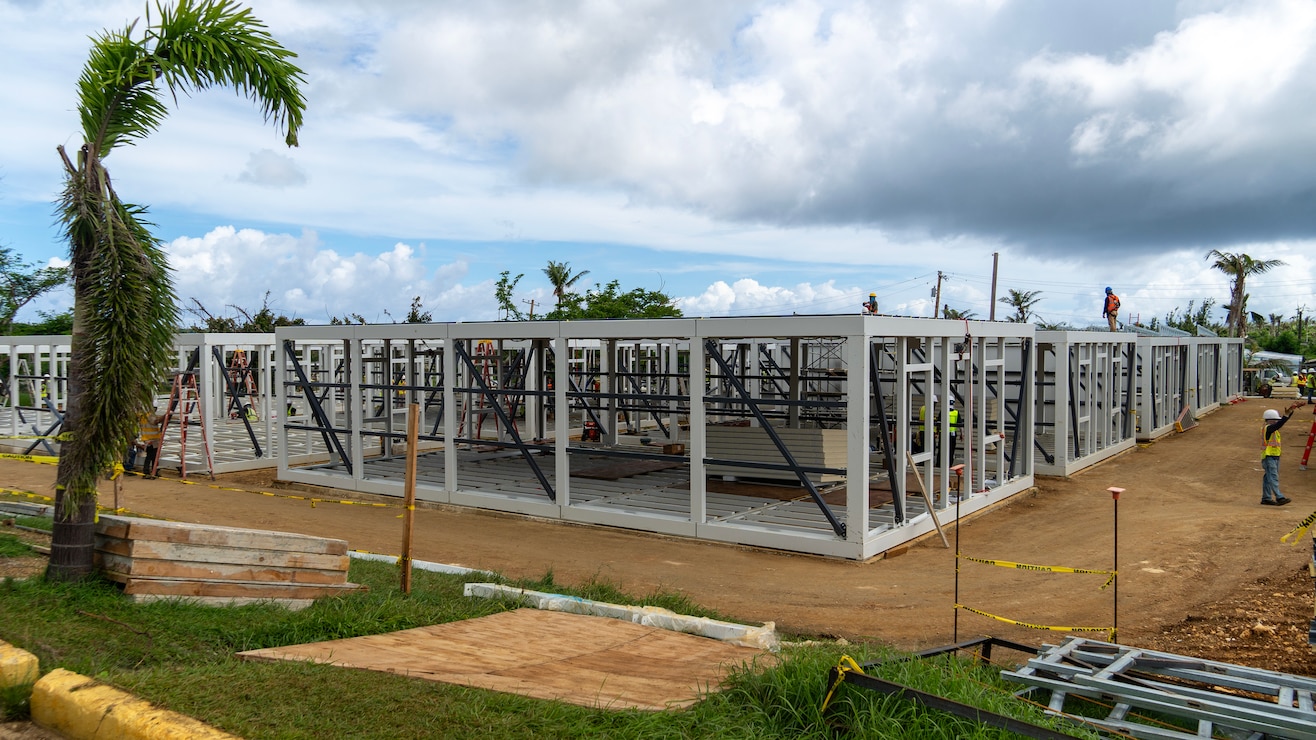Construction workers assemble a steel building structure.