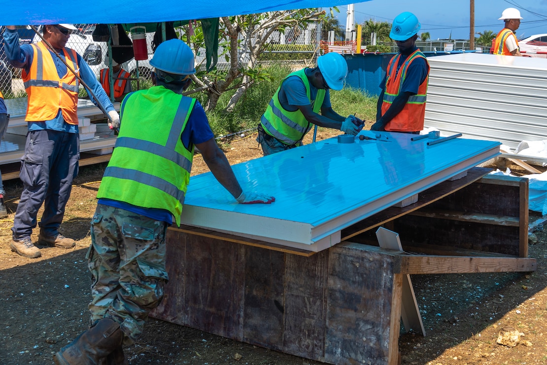 Construction workers assemble a steel building structure.
