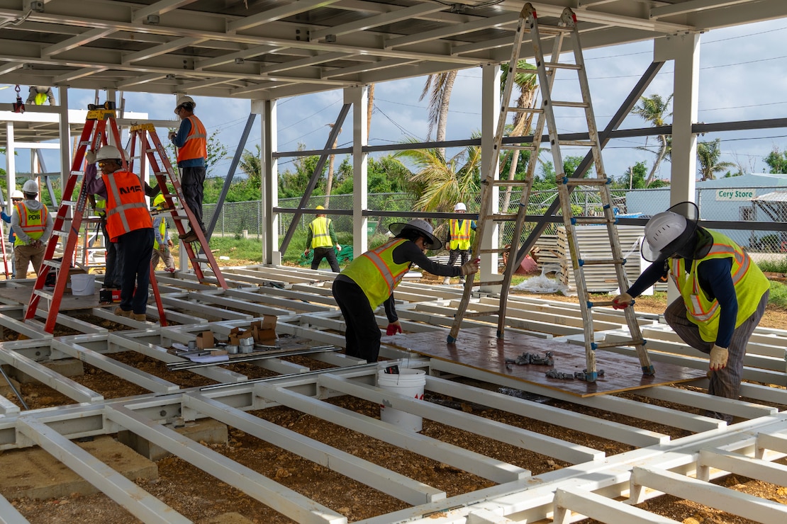 Construction workers assemble a steel building structure.