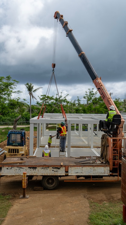 Construction workers assemble a steel building structure.