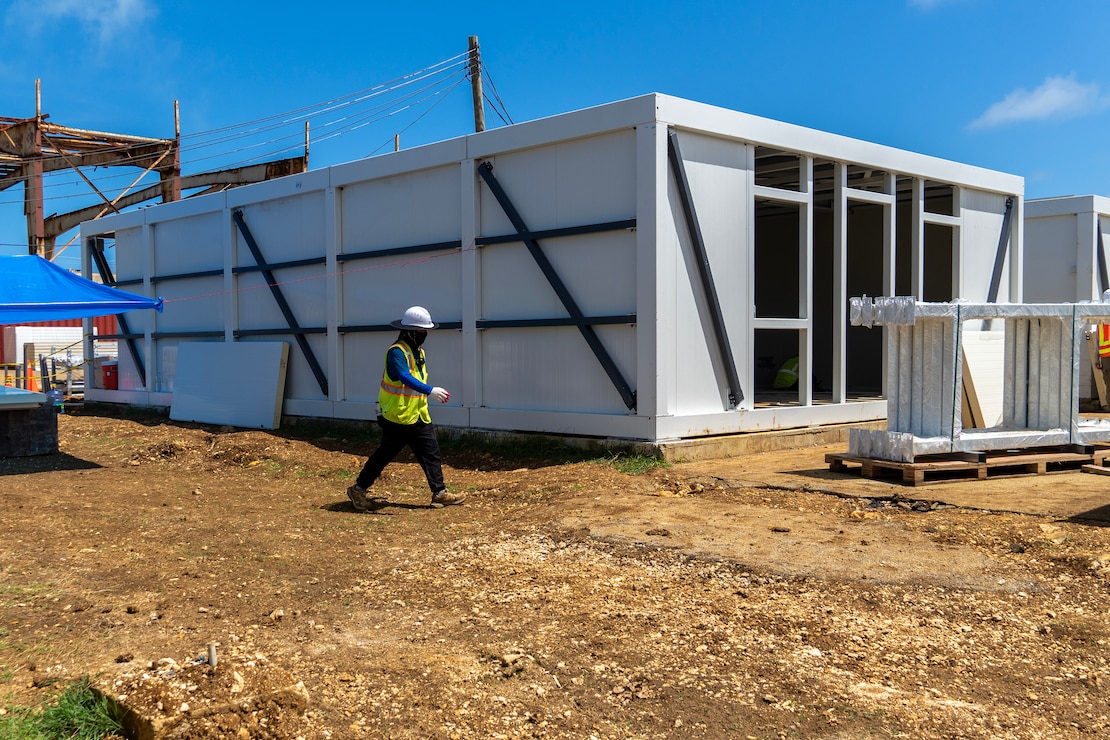 Construction workers assemble a steel building structure.