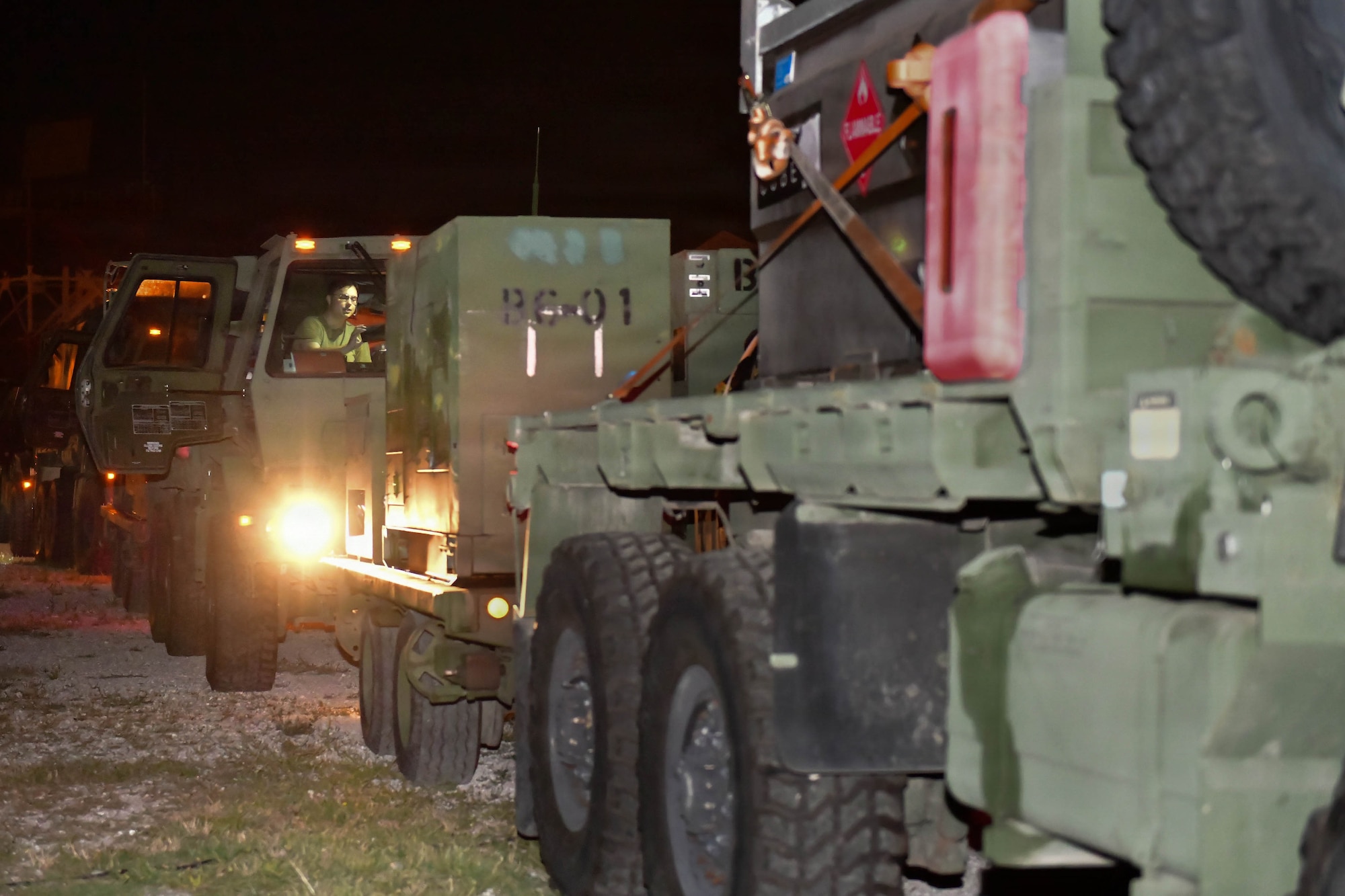 A line of trucks prepares to drive during the night.