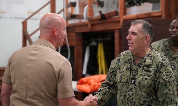 SAN DIEGO (Aug. 7, 2026) Acting Surgeon General and chief, U.S. Navy Bureau of Medicine and Surgery, Rear Adm. Matthew Case (right) presents a command coin to Cmdr. Ryan Smith, operational health director (left) at Naval Health Research Center (NHRC). NHRC, part of Navy Medicine Research & Development, supports Navy, Marine Corps and joint U.S. warfighter health readiness and lethality with research and development that delivers high-value, high-impact solutions to the health and readiness challenges that the U.S. military population faces on the battlefield, at-sea, home and abroad. (U.S. Navy photo by Danielle Cazarez/Released)