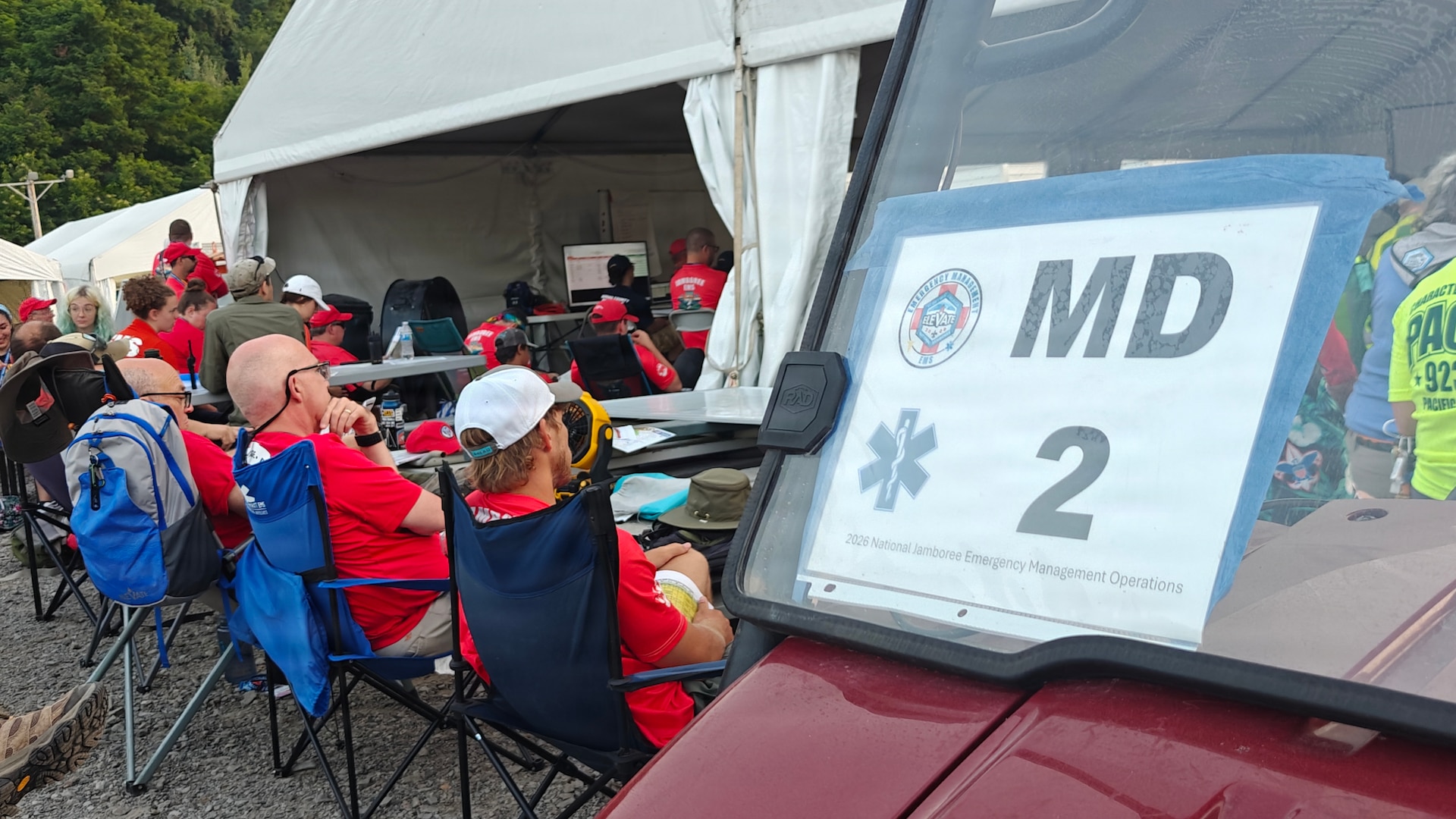 Group of people sitting by tent with a MD sign