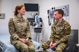 A family medicine physician, simulates a patient screening with Senior Airman Sofia Colesanti.