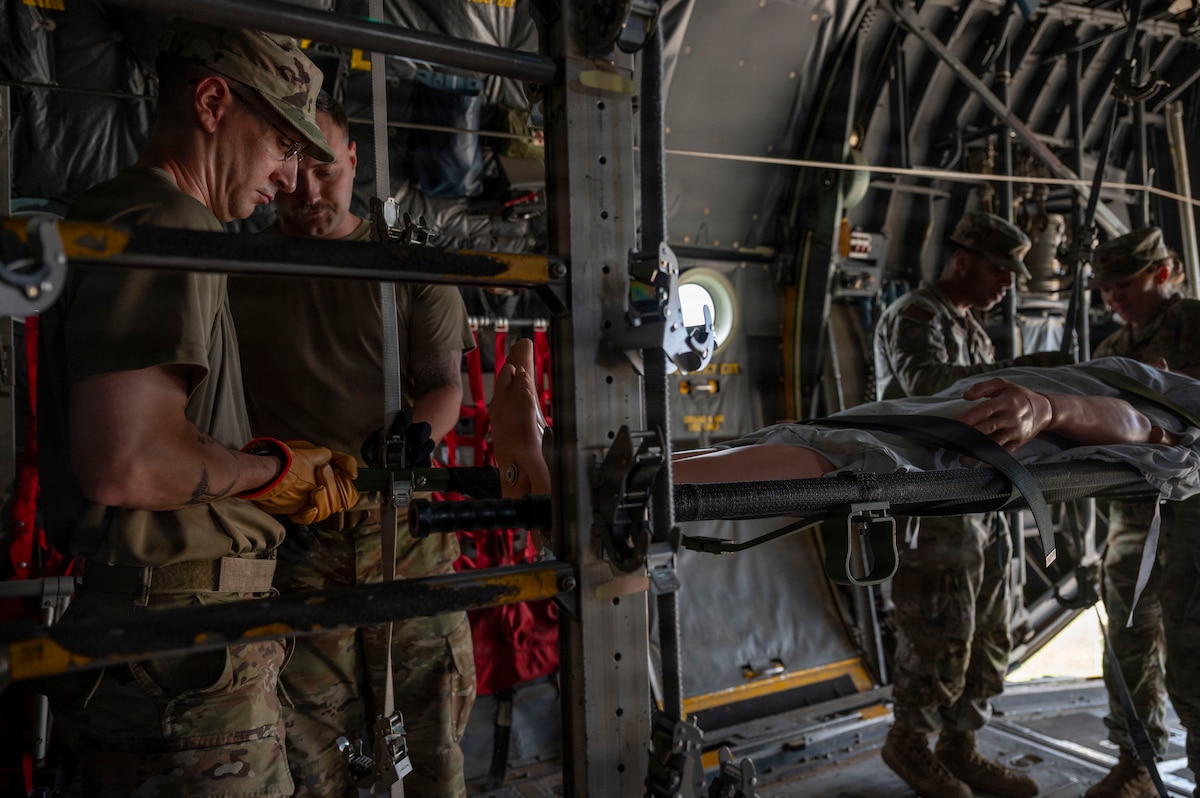 U.S. Air Force students, participating in the Aeromedical Evacuation Patient Staging Course with the 937th Training Squadron, loading a simulated patient onto a C-130 Hercules airframe at Joint Base San Antonio-Camp Bullis, Texas, June 22, 2026. The training teaches Air Force medical personnel how to safely prepare, secure and transport patients aboard military aircraft during contingency and deployment operations. (U.S. Air Force photo by Melissa Hydrick)