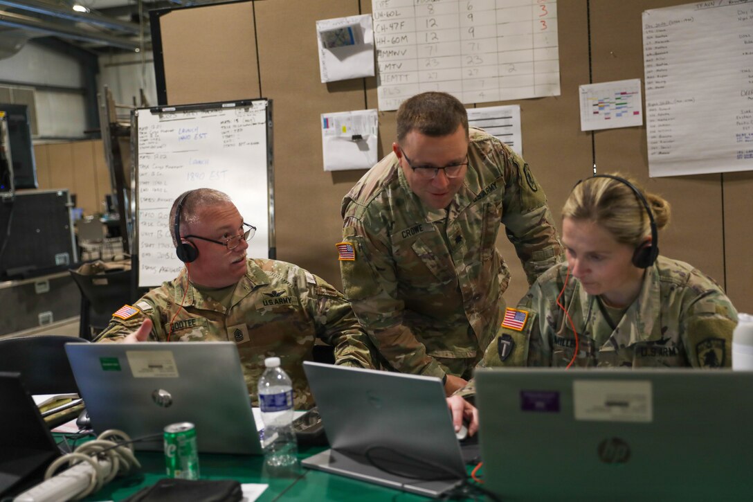 U.S. Army Lt, Col. William Crowe (center), the officer in charge, goes over the missions with Sgt. Maj. Jerry ‘Allen’ Gootee (left), operations sergeant major, and Maj. Jessica Miller (right), the Brigade S3 (operations, training and plans), all with the 63rd Theater Aviation Brigade, during Vibrant Response 2026 at Camp Atterbury, Indiana, Apr. 23, 2026.