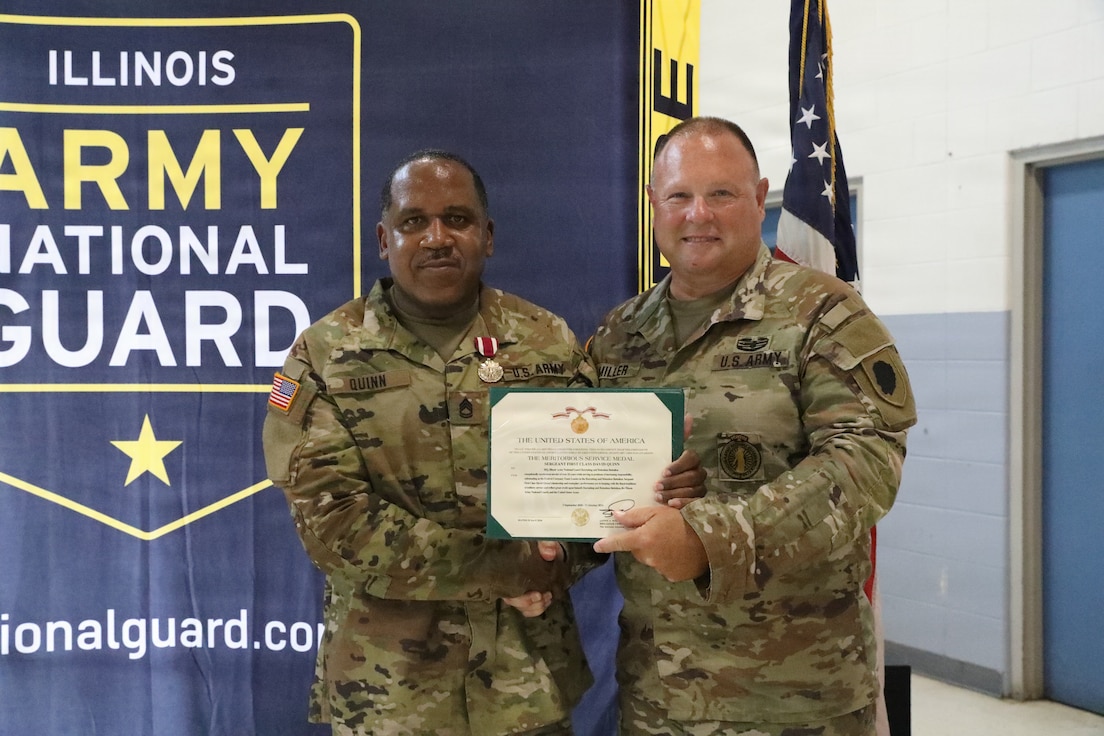 Army National Guard Sgt. 1st Class David Quinn, left, receives the Meritorious Service Medal