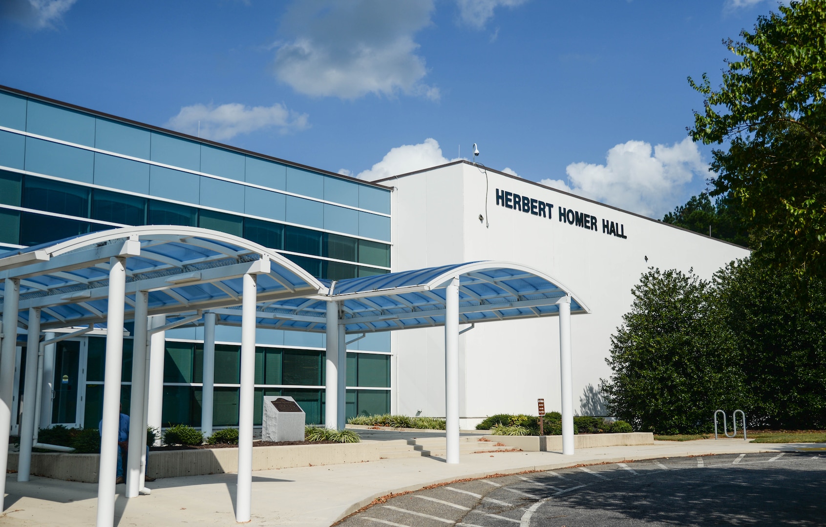 The outside of a large white building with the name Herbert Homer Hall in letters on the outside wall.