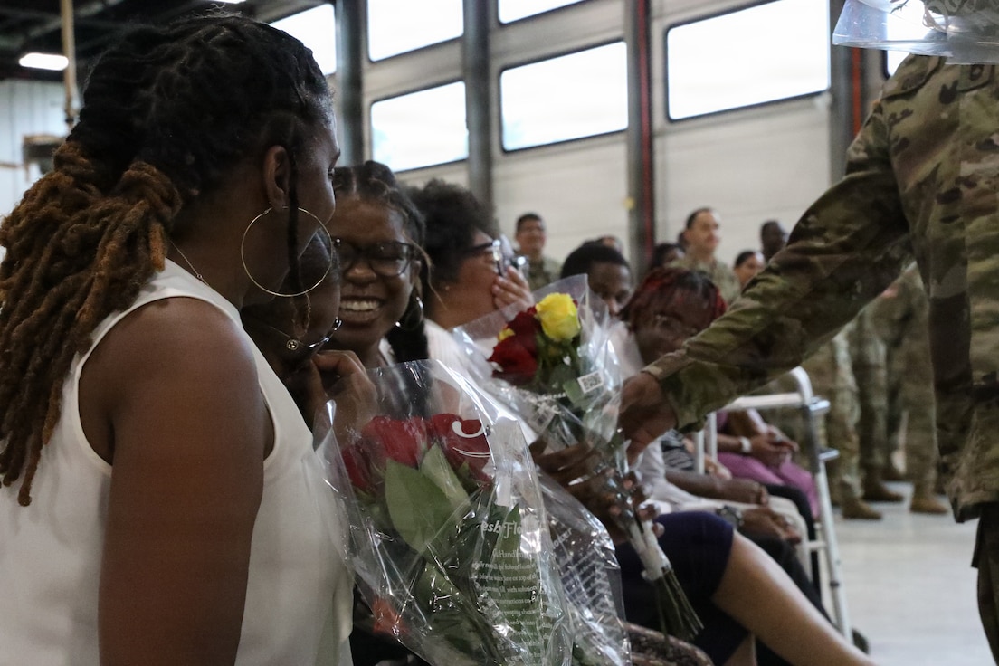 Family members of U.S. Army Sgt. 1st Class David Quinn accept flowers of appreciation during his retirement ceremony at the Crestwood Armory