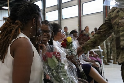 Family members of U.S. Army Sgt. 1st Class David Quinn accept flowers of appreciation during his retirement ceremony at the Crestwood Armory