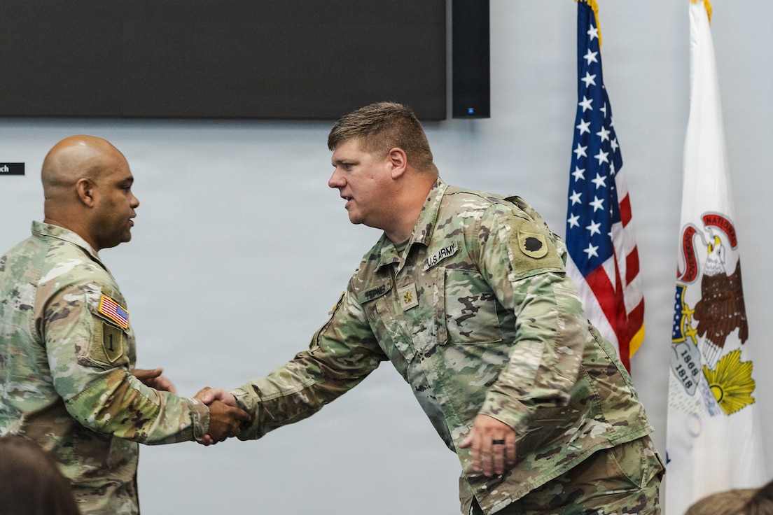 Lt. Col. Aaron A. Hepner shakes hands with Col. Jason Carter, commander of the 65th Troop Command