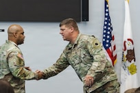 Lt. Col. Aaron A. Hepner shakes hands with Col. Jason Carter, commander of the 65th Troop Command